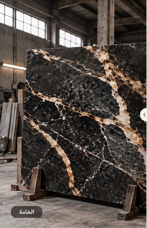 Raw black marble slab with gold veining in the factory before processing